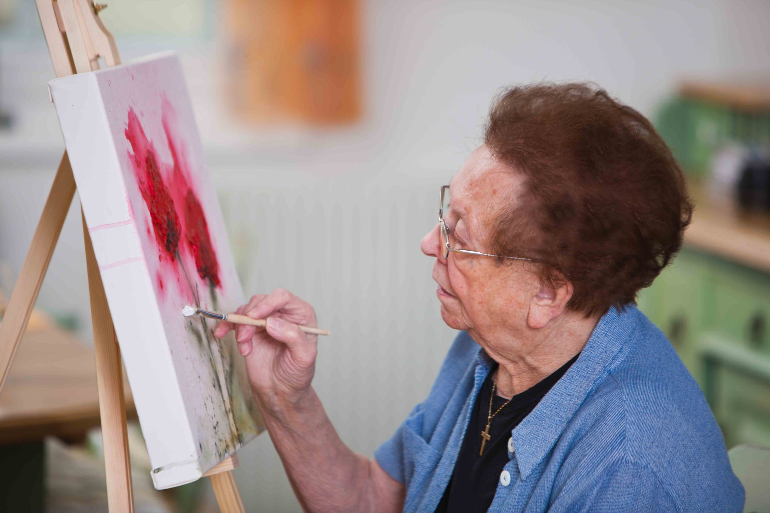 Alte Frau malt ein Bild
